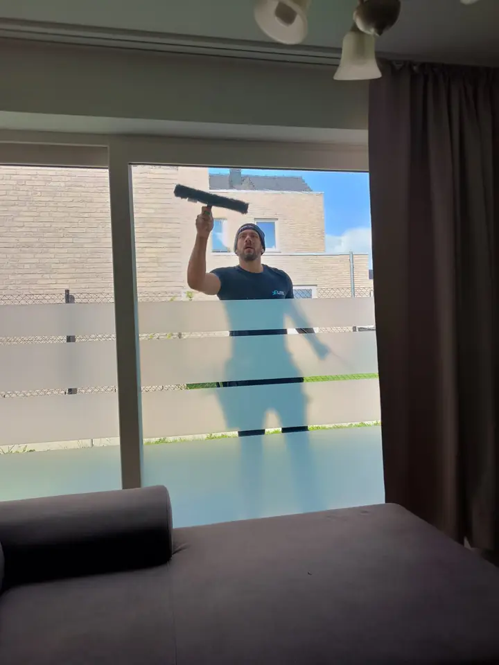 Tino wast een raam bij een klant thuis